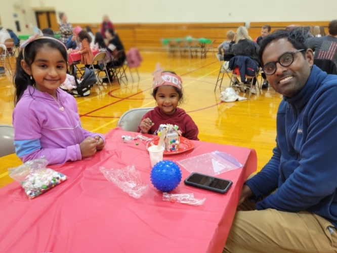 parents sitting at table with child at gingerbread night